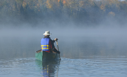 Man in a canoe on a lake.